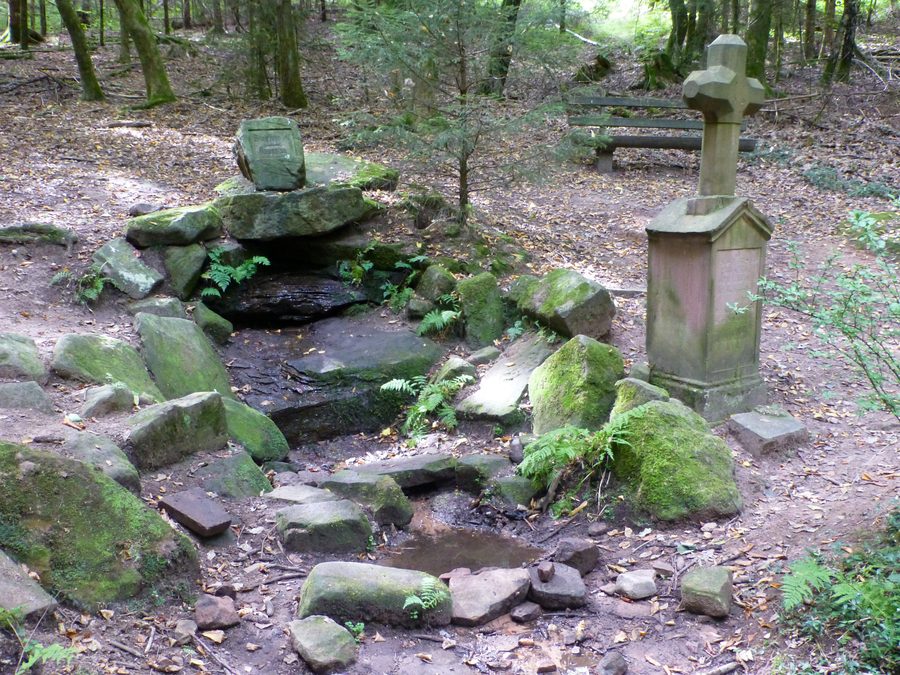 Siegfriedbrunnen südöstlich von Gras-Ellenbach mit einem Steinkreuz im Wald